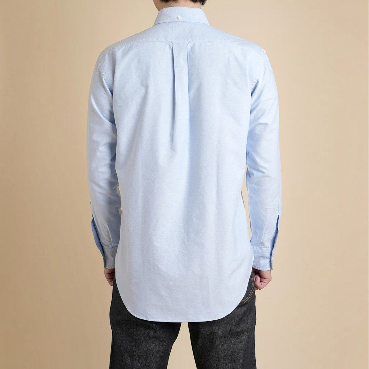 Back view of a MILWORKS light blue cotton oxford button-down shirt featuring a box pleat and locker loop.
