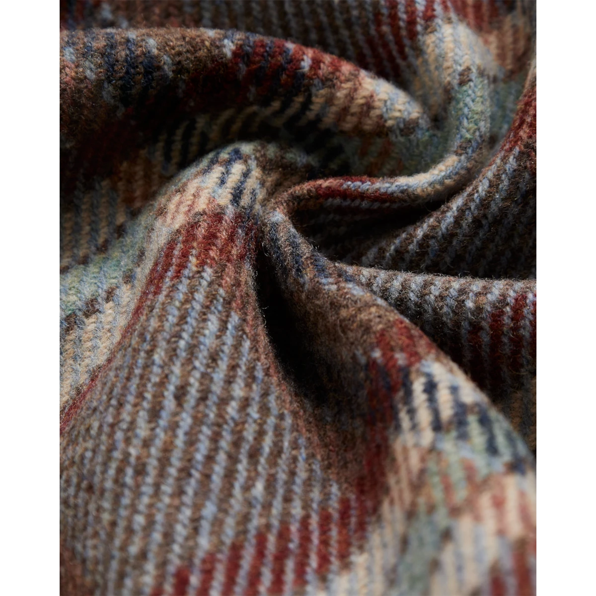 Close-up of MILWORKS Portuguese Flannel wool field overshirt featuring a multi-colored plaid pattern in earth tones.